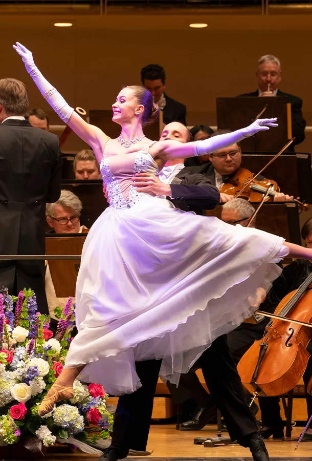 Salute to Vienna dancer posing in front of orchestra