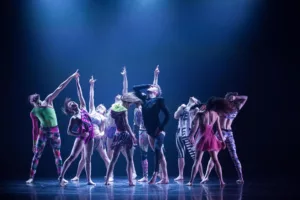 Group of dancers on stage under a spotlight