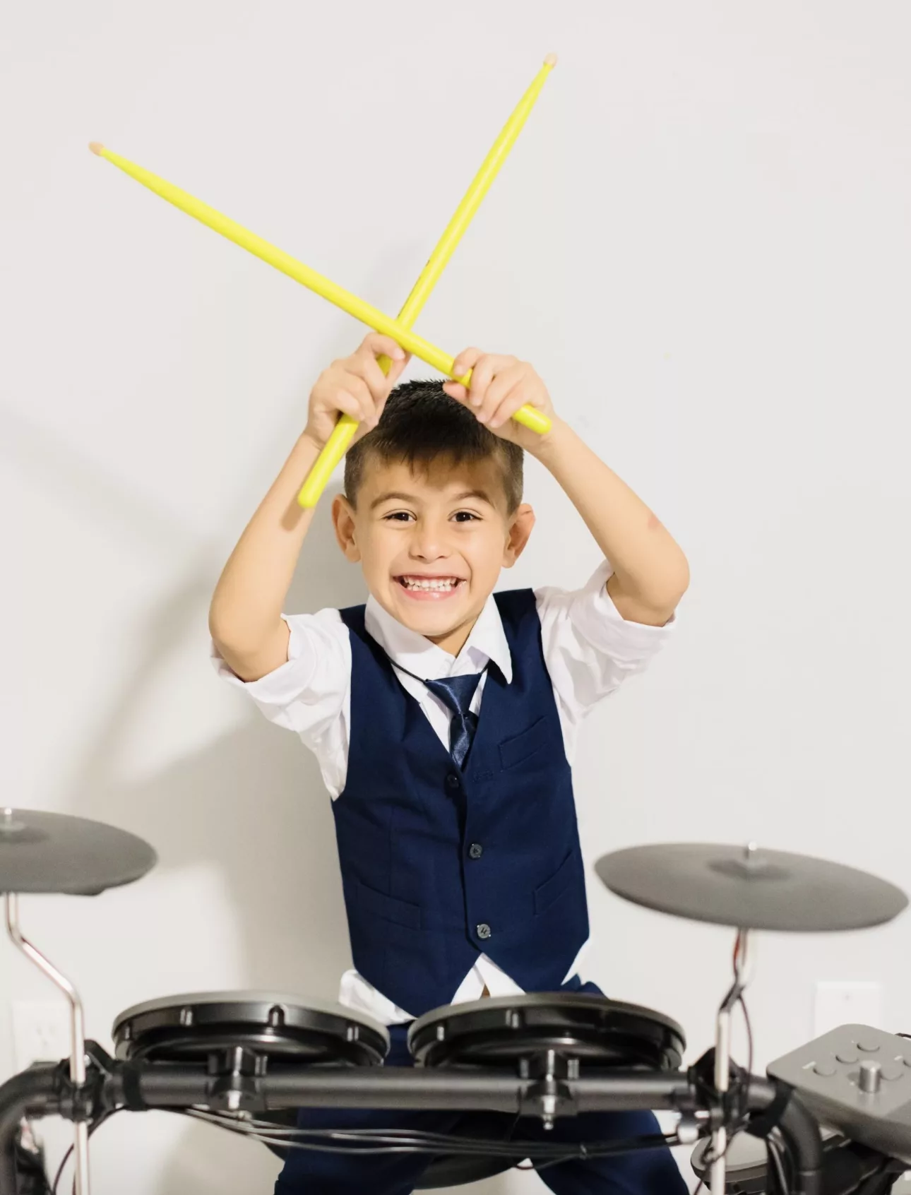 boy sits behind drum set