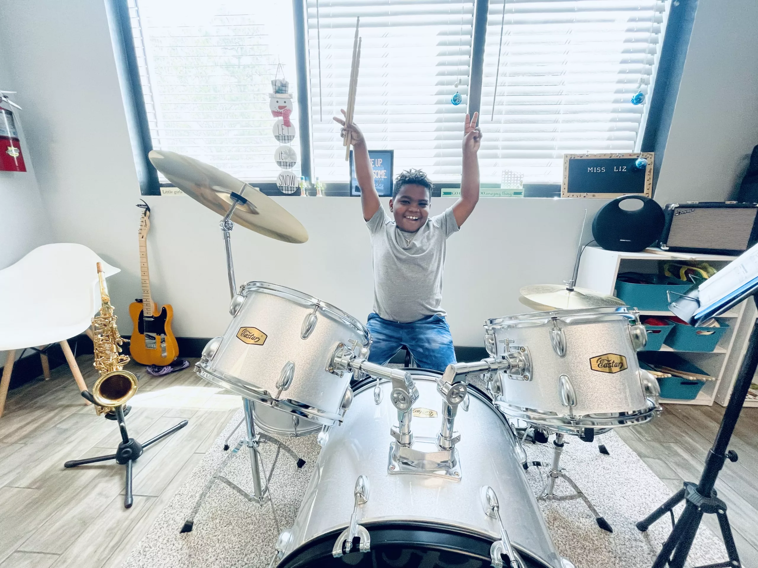 boy sits behind drum set