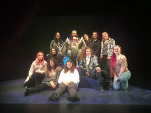 Group photo of people smiling with a vulture puppet