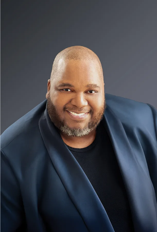 Limmie Pulliam headshot wearing blue dinner jacket smiling into camera.