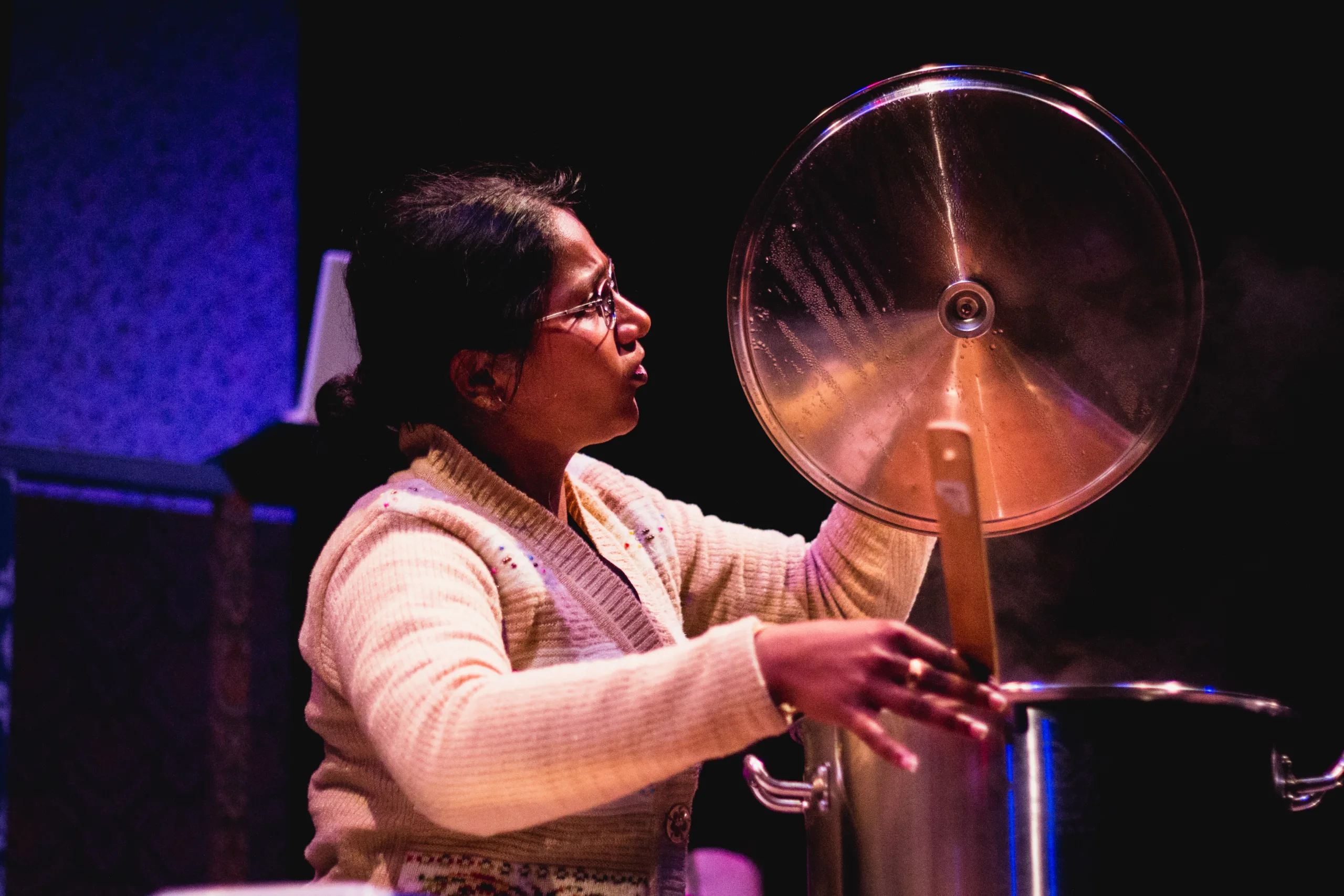 women holding up large pot lid. Photo Credit Ankita Singh